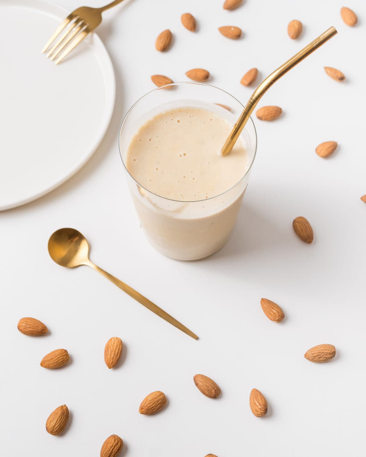 Almond shake with almonds scattered around it