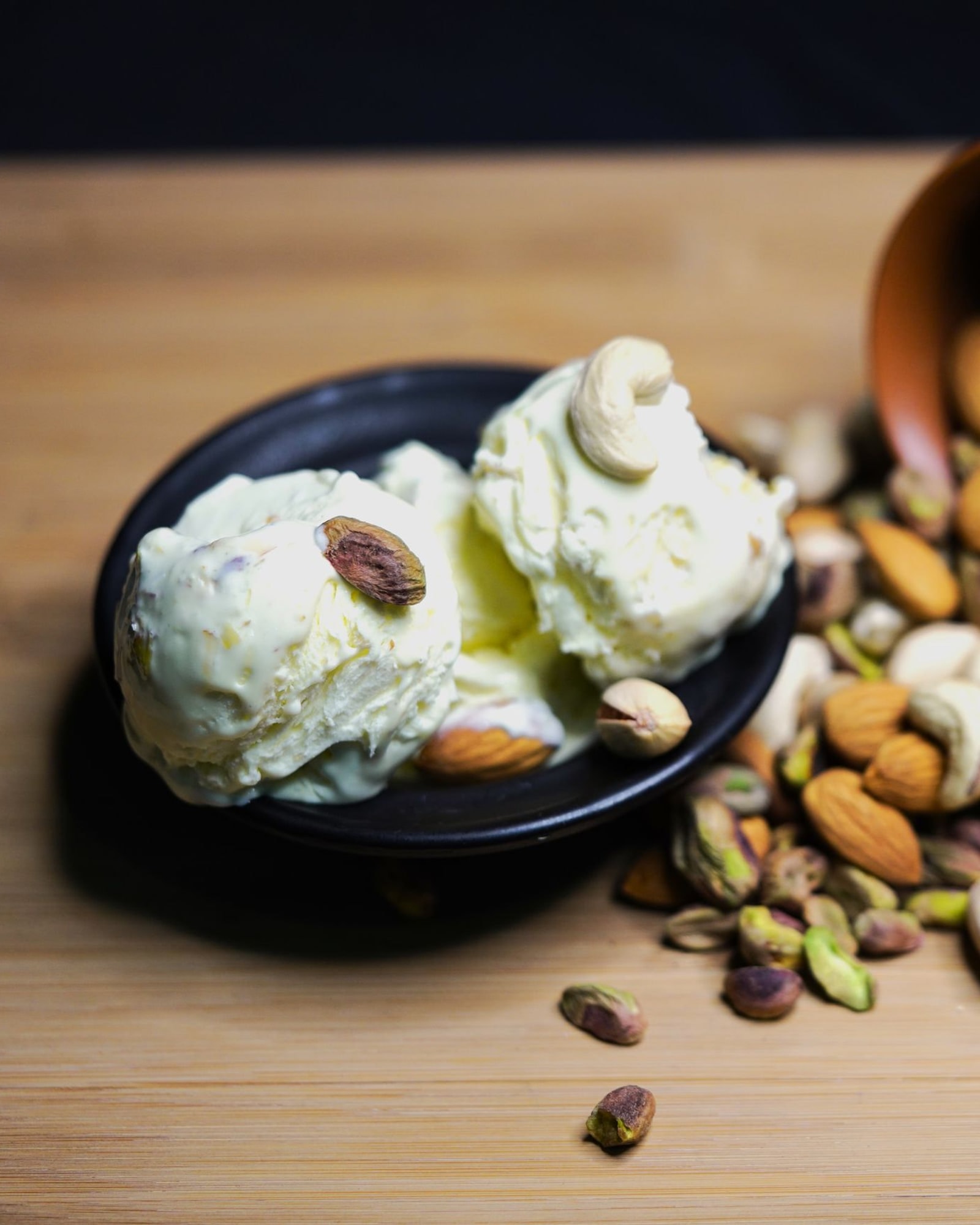 Ice cream scoops topped with pistachios and almonds